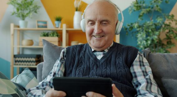 Persona mayor sonríe a la pantalla mejorando su bienestar emocional con inteligencia artificial Amy